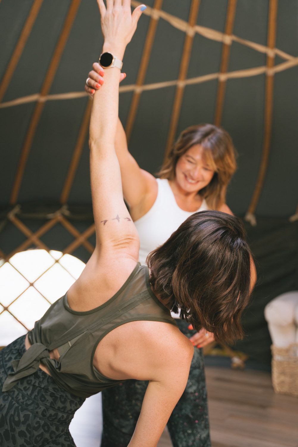 Lucy guiding a student's raised arm from behind