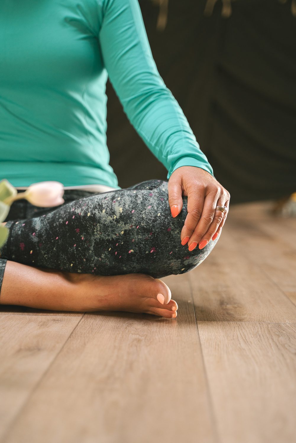 Lucy adjusting a student in a side-angle pose, one hand on the student's back